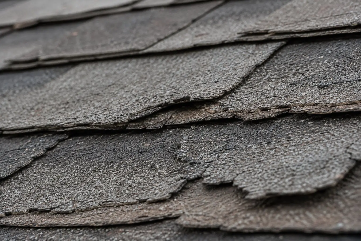 Close-up of aging and cracking asphalt shingles on a Pataskala Ohio subdivision home showing signs of end-of-life wear